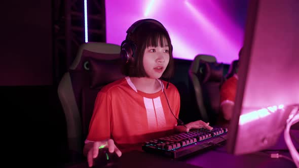 Portrait of a Asian Female Gamer in Headphones Plays a Video Game Cyber Sportsman at the Game alt