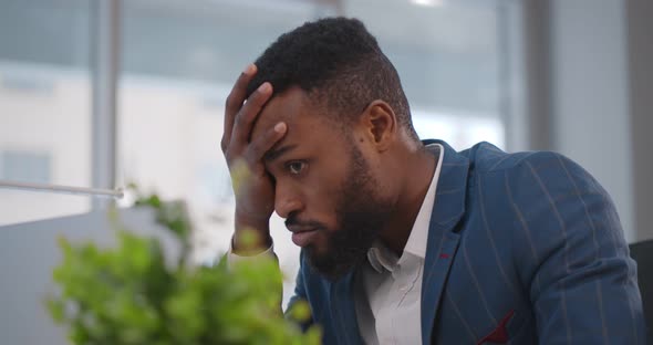 Close Up of Stressed and Upset African Man with Laptop Working at Office alt