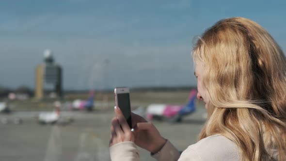 girl photographs on the phone the plane standing at the gangway