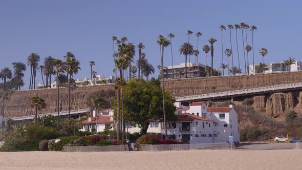 Panning dolly shot of Santa Monica coastline along the famous Pacific Coast Highway.  Cliffside alon alt