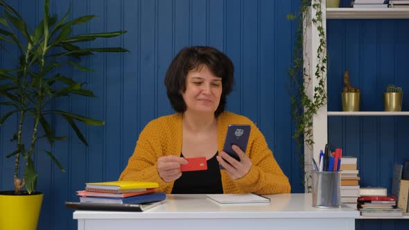 Middle Aged Woman Using Credit Card for Online Shoping