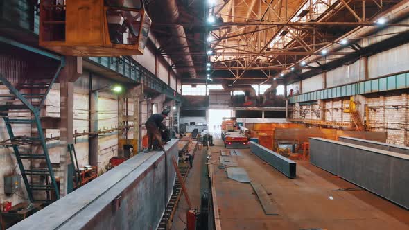 Plant for the Construction of Cranes - People Working in There - the Process of Welding alt