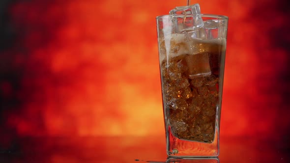 Pouring Cola with Ice Cubes Close-up. Cola with Ice and Bubbles in Glass alt