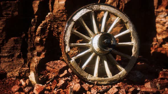 Old Wooden Cart Wheel on Stone Rocks alt