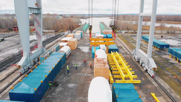 Cargo Port - A Big Industrial Crane Loading the Cargo on the Freight Carriage on Rails alt