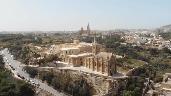 4k aerial drone footage circling the Church Ghajnsielem Parish in the Mediterranean town of Mgarr alt