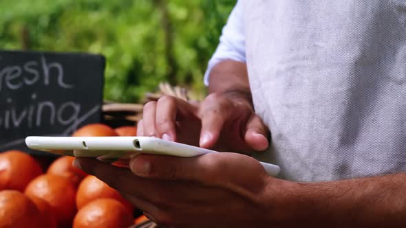 Mid section of man using digital tablet alt