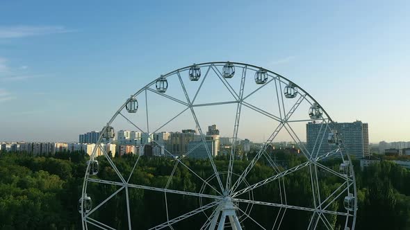 Huge Ferris Wheel, People Are Sitting in Booths, Entertainment in the Park. View From a Copter