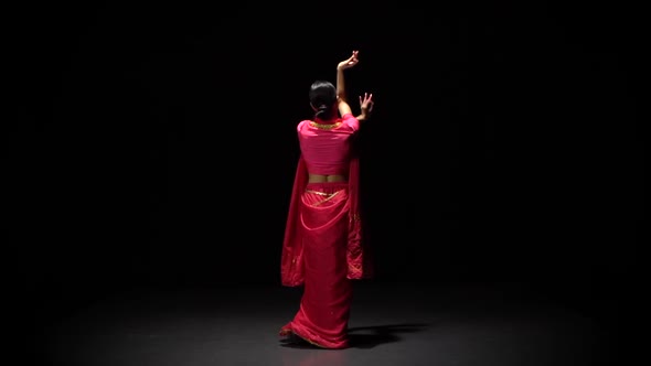 Back View Belly Dance of Young Woman in Shiny Red Dress, on Black Background, Slow Motion. alt