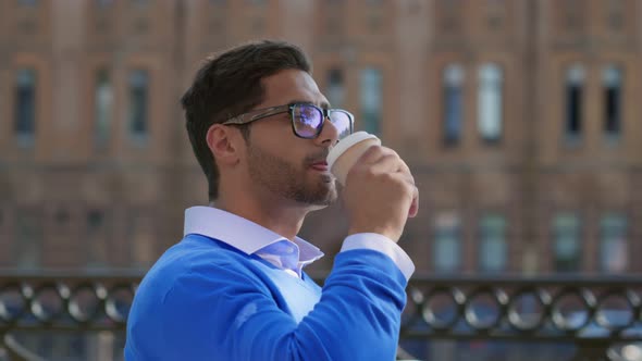 Close Up of Handsome Indian Office Employee Having Coffee to Go Outdoors alt