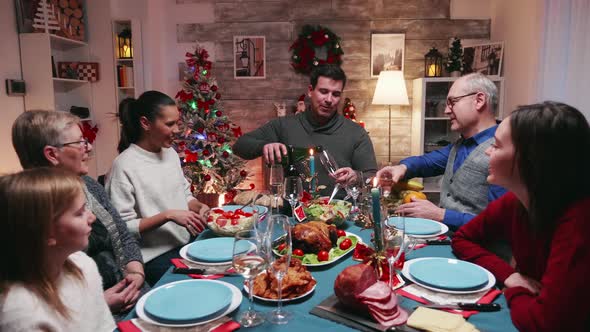 Young Man Clinking a Glass of Champagne with His Father alt