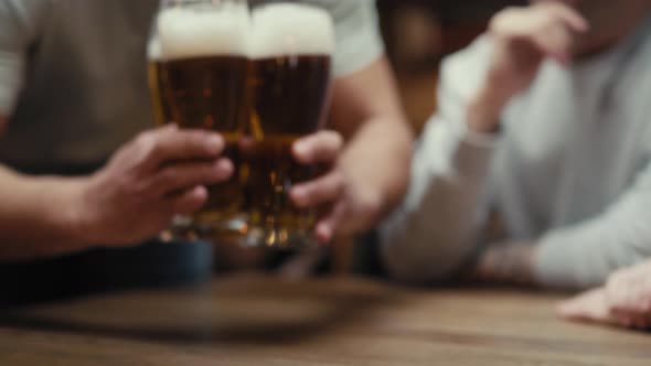 Close up of unrecognizable man bringing beer glasses for friends. Shot with RED helium camera in 8K. alt
