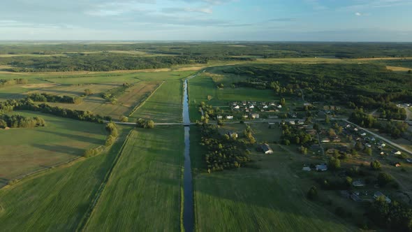 River In The Green Valley. On The Shore You Can See The Village Among The Forest. alt