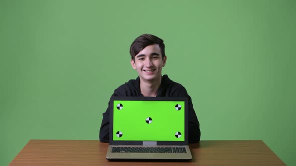 Young Handsome Iranian Teenage Boy Against Green Background alt