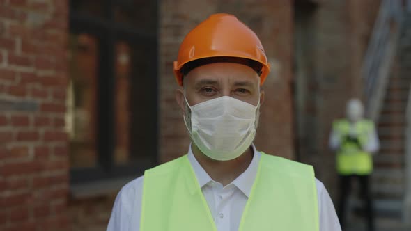 Portrait of Builder in Hardhat and Medical Mask Outdoor alt