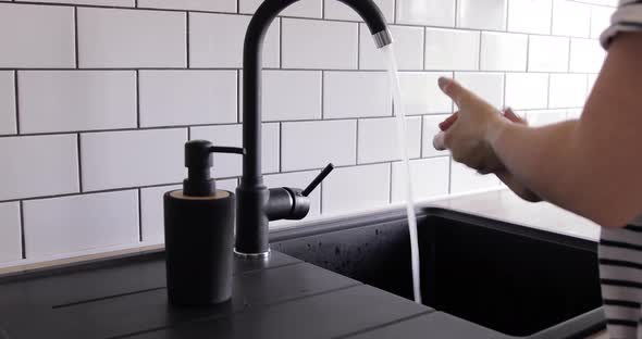 COVID-19 Coronavirus Washing Hands With Liquid Soap Under Running Water On Home Sink. Medium Shot alt
