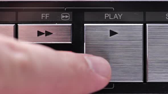 Extreme close up of buttons on an old antique or vintage VCR Pushing the Play button alt