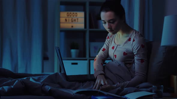 Teenage Girl with Laptop Learning in Bed at Night