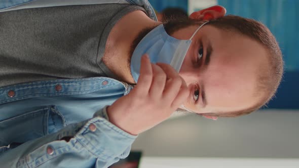 Vertical Video Portrait of Man Putting on Protection Mask Looking at Camera alt