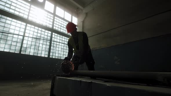 Construction Worker Cuts Steel with a Circular Saw Construction Worker's Feet Flying Sparks From a alt