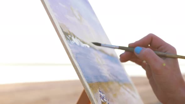 Young Woman Artist Painting Landscape in the Open Air on the Beach Close Up alt