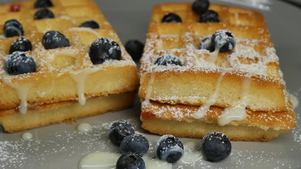 Sprinkle Belgian Waffles with Condensed Milk and Blueberries with Sweet Powder