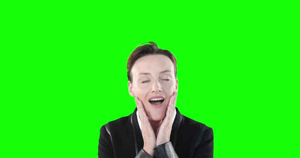 Surprised Caucasian woman smiling at camera on green background