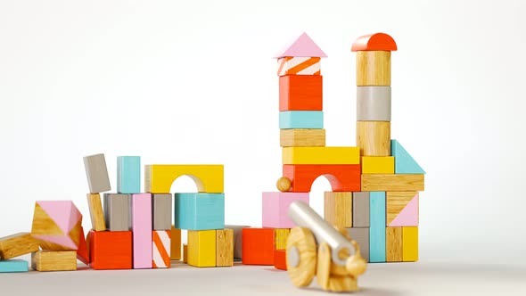 Toy cannon demolition of a castle made out of colorful, wooden blocks. 4K HD alt