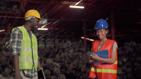 African American male and female workers greet and consult in warehouses during overtime.