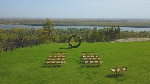 Wedding Venue and Chairs on Field on Sunny Day Upper View alt