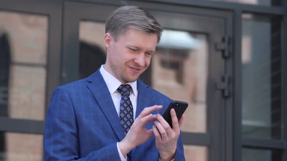 Portrait of Businessman Busy Using Smartphone alt