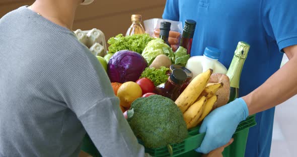 Woman customer checking grocery in the basket that ordered online and delivered by deliveryman