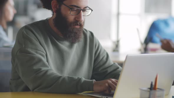 Young Bearded Man Posing for Camera at Office Workplace alt