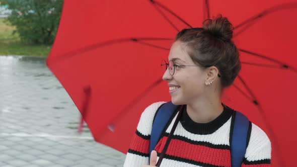 Girl Looking at Camera Twirling Red Umbrella alt