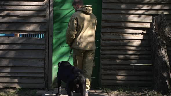Back View Man Opening Dog Training Center Door in Slow Motion Entering with Cane Corso Leaving alt