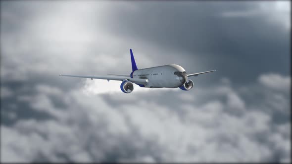 A white plane with a blue tail is flying in gray clouds alt