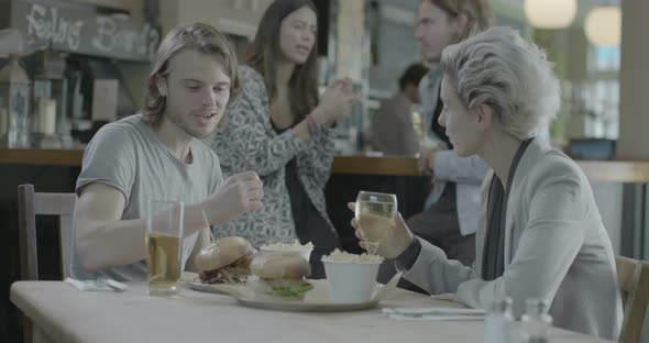 Men and women having drink and talking in pub