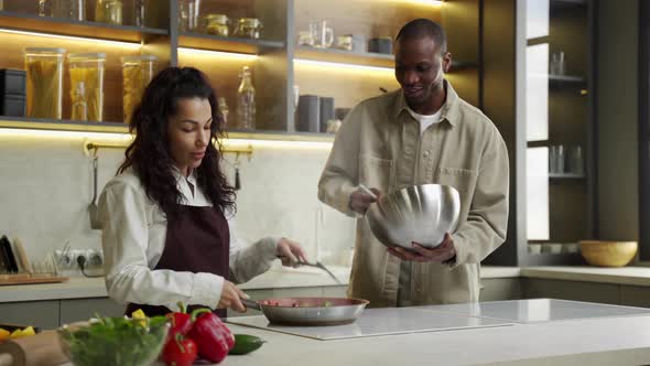Young Multiracial Couple Cooks Dinner Together in Kitchen alt