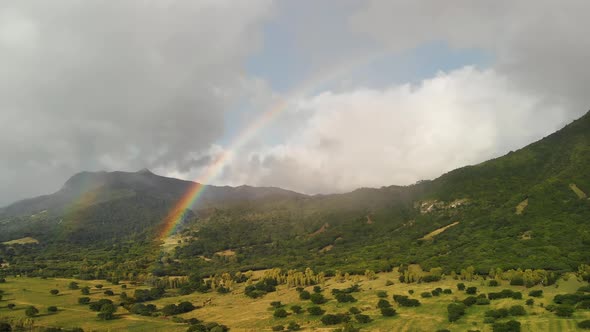 Beautiful Island Hills with Rainbow at Sunset alt