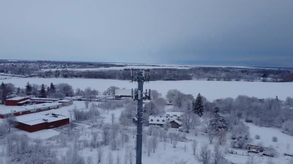 Aerial snow covered radio tower during a winter day alt