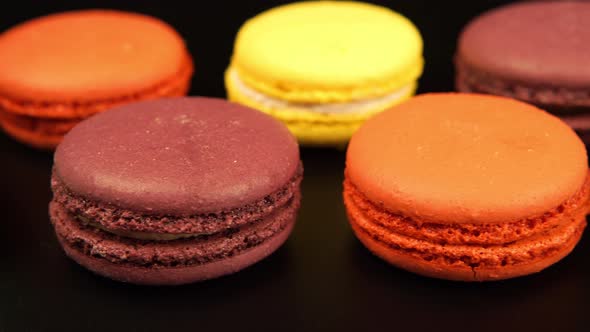 A rows of a colorful macaroons is on the black table