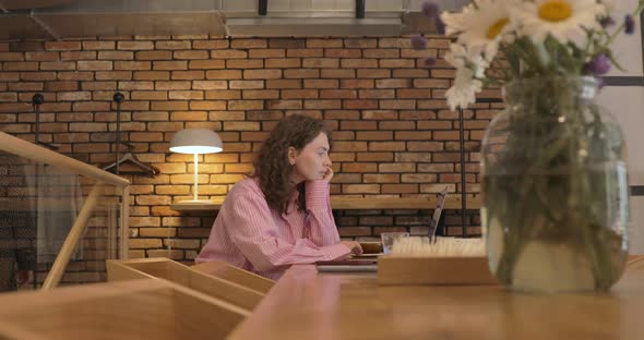 Young woman using laptop computer surfing social media, checking news, texting messages. alt