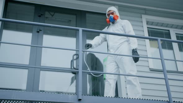 Man Disinfect Spray Handrail City Street. Corona Virus. Covid-19. Coronavirus. alt