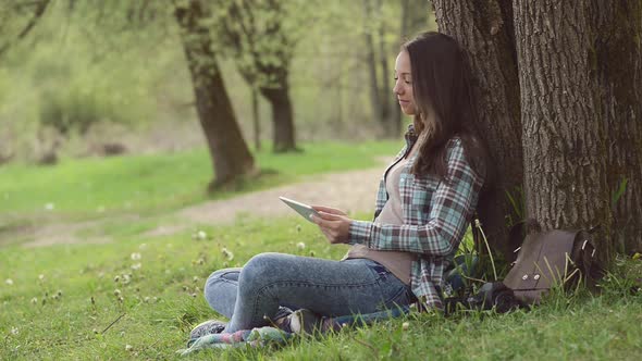 Beautiful girl at the park using a tablet
