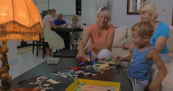 Grandmothers playing with grandson at home alt