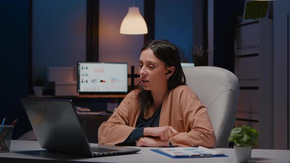 Businesswoman with Headphones Discussing Marketing Statistics alt