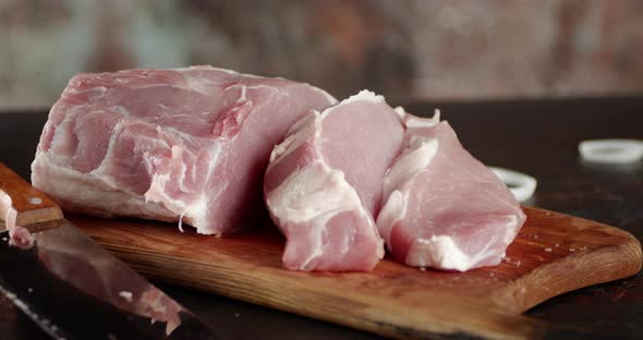 Sliced Raw Pork on a Cutting Board Rotates.  alt