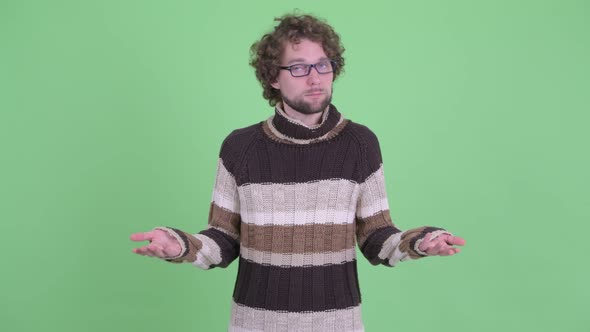 Confused Young Bearded Man Shrugging Shoulders alt