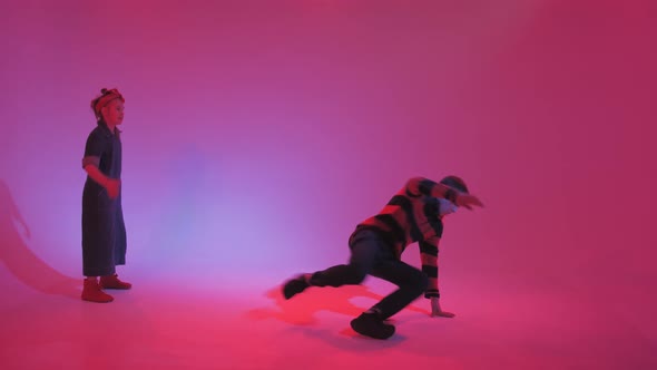 Young Stylish Girl Dancing in the Studio on a Colored Neon Background
