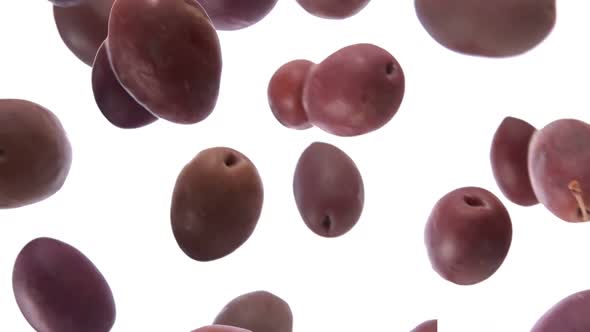 Large Delicious Dark Olives are Falling on the White Background alt